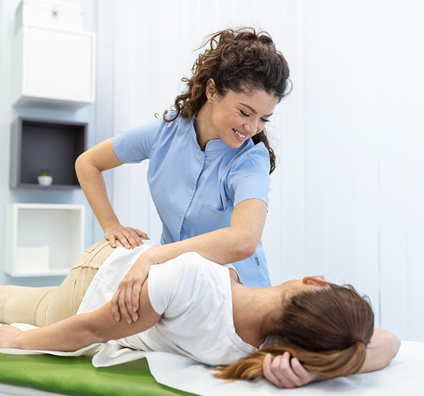 A close-up of a massage therapist applying oil to a client's back.